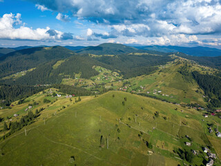 Green mountains of Ukrainian Carpathians in summer. Sunny day, rare clouds. Aerial drone view.