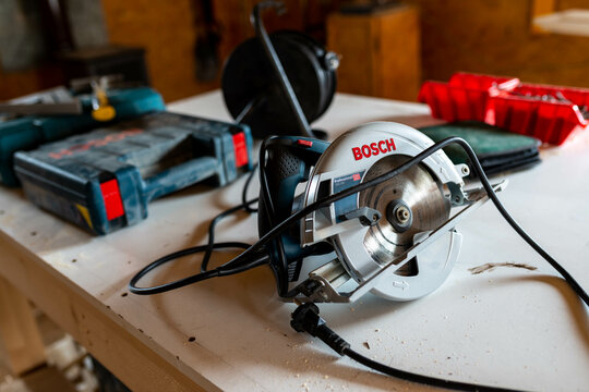 Miercurea Ciuc, Romania- 23 April 2022: Bosch GKS 190 circular saw , power tools on the table in a small woodworking shop.