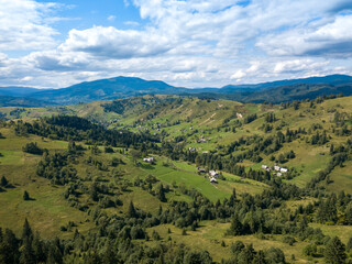 Green mountains of Ukrainian Carpathians in summer. Coniferous trees on the slopes. Aerial drone view.