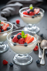 Delicious and cold Panna Cotta with raspberries and blueberries.