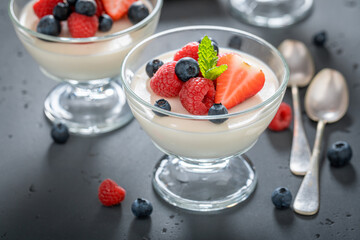 Fresh and sweet Panna Cotta served in glass with berries.