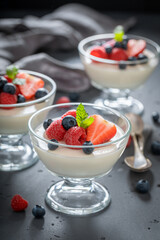 Homemade and tasty Panna Cotta with raspberries and blueberries.