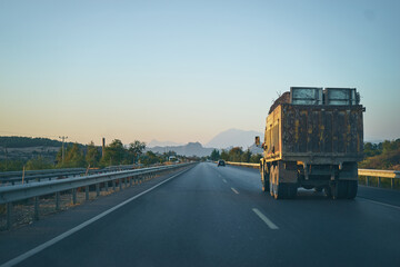 Cargo transportation. A truck full of cargo moving on a highway.