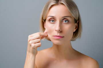 Naklejka premium Natural beauty. Blonde woman with healthy skin. No makeup. Grey background.