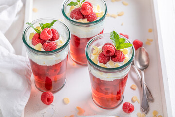 Fresh red jelly with raspberries, cream and almonds.