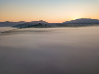 Sunrise over the fog in the Ukrainian Carpathians. Aerial drone view.