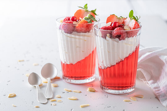 Sweet and fresh red jelly as summer dessert with cream.