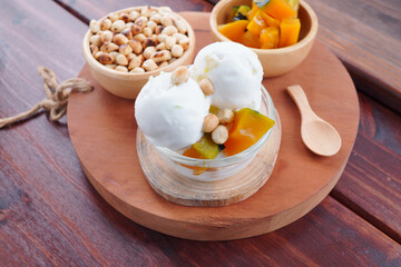 Traditional coconut milk ice cream topped with milk and roasted peanuts.