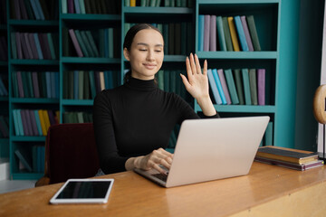 A modern woman with glasses designer works in an office, uses a computer tablet, communicates online with a client.