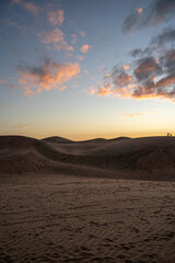 Vertical shot of colorful sunset on the dunes of Concon and silhouettes in the background, Chile