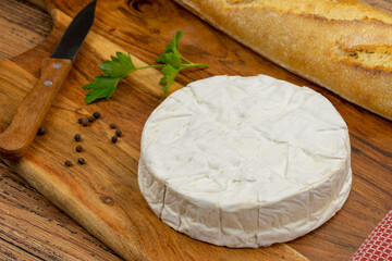 camembert on a wooden board with bread