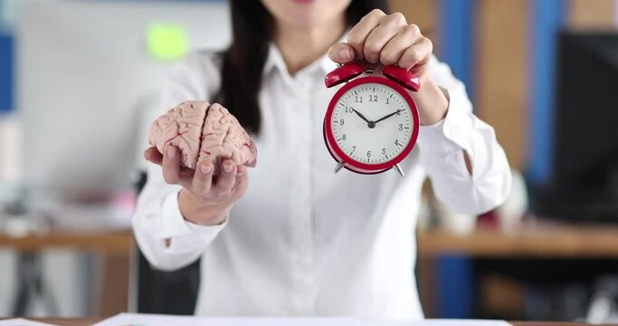 Businessman holding a brain and an alarm clock