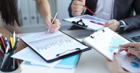 Business team studies financial indicators in charts