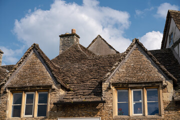 Fototapeta na wymiar stone mullion windows and stone roof tiles of an 18th Century property in quintessential English village of Lacock Wiltshire