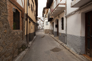 Narrow Spanish Village Street.  Taken in San Esteban del Valle.  Deserted because it's siesta time. - obrazy, fototapety, plakaty