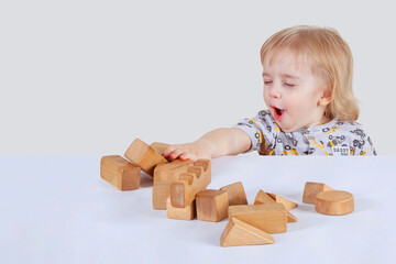  The baby toddler is emotional, with great joyplaying by wooden cubes. (concept  fun games)