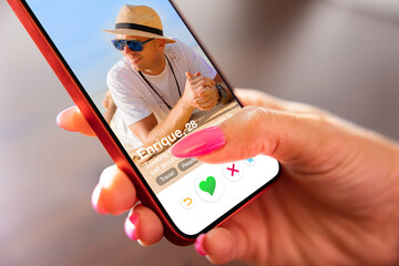 Woman using online dating app on her mobile phone - obrazy, fototapety, plakaty