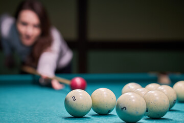 Blurry silhouette of a girl playing billiards