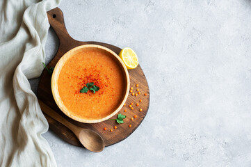 Traditional Turkish red lentil soup with ingredients in bowl on rustic table