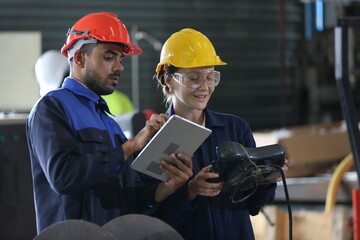 engineer checking control panel and teaching new Automatics robot arm and operating control machine in factory.