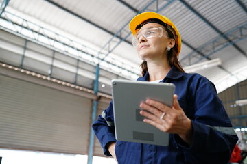 Professional young industrial factory woman employee working with machine parts putting, checking and testing industrial equipments and robot arms in large Electric electronics manufacturing plant 