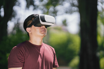 Young man using VR virtual reality headset with nature background for connect future digital...