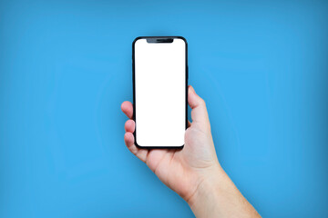 Hand holding the black smartphone with blank screen and modern frame less design on blue colour background