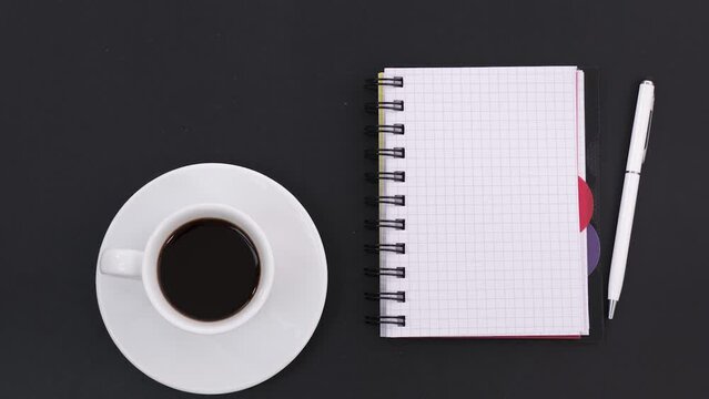 Stop motion animation black chalk board or table with coffee cup, note book and pen. Morning at the office.