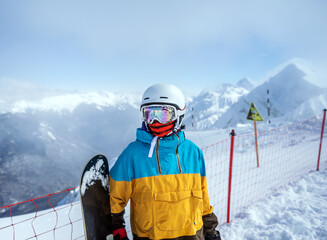 Portrait of woman snowboarder on background beautiful landscape of snowy high mountains of Caucasus...