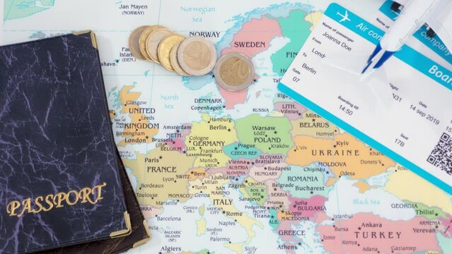 Euro coins, boarding passes or tickets, passport and toy plane over a map of Europe. Concept of international travels, tourism, business trips.