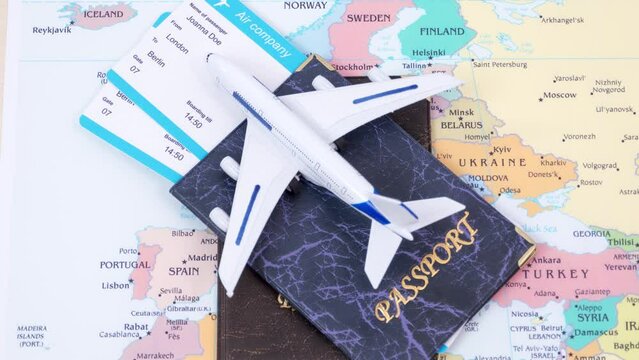 Passport, tickets and toy airplane appear on the map of Europe