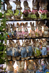White Easter bunny rabbit with shopping basket and painted eggs on blue and pink background