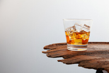 Whiskey or alcoholic beverages or bourbon with ice on the wooden floor and a black and white scene with a top view