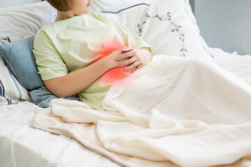 Stomach ache, symptoms of gastritis or pancreatitis, woman with abdominal pain suffering at home