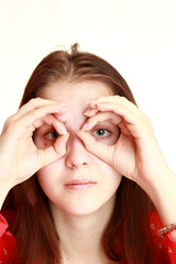 A young girl in a red dress looks into the distance.