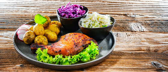 Baked chicken leg with potatoes and vegetable salads