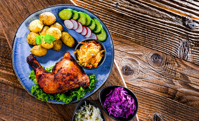 Baked chicken leg with potatoes and vegetable salads