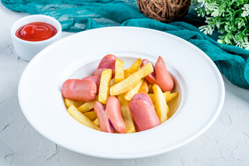 french fries with sausages and ketchup on white bowl