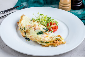 omelette with salmon and vegetables,breakfast on a white plate