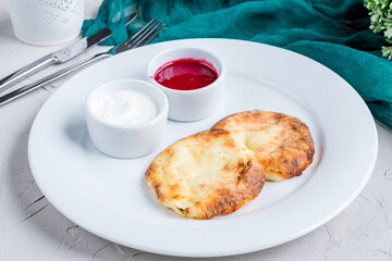 cheesecakes from cottage cheese and raspberry sauce on a white plate