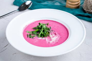 cold beetroot soup on a white bowl on grey table