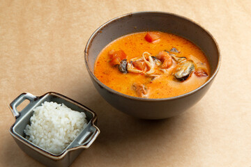 Traditional tom yum soup. On a brown background.