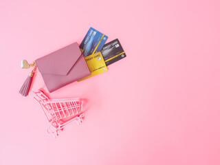 shopping and payment concept from pink wallet with credit cards or discount card on pink background.