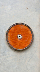 Obraz na płótnie Canvas Reflector redondo naranja en superfice metálica