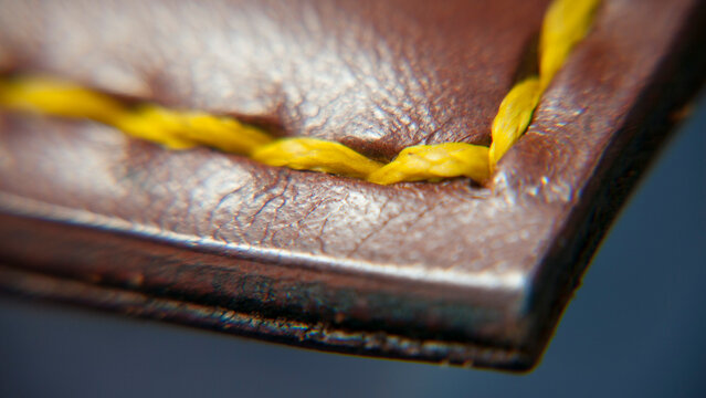 Detalle de encuadernaci&oacute;n de genda de cuero marr&oacute;n con pespunte amarillo