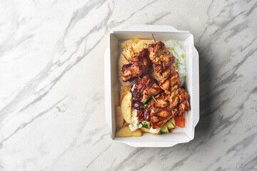 Greek souvlaki,salad and gyros take away menu from fastfood restaurant served in recyclable paper plates on table.