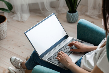 Young woman using laptop screen mockup to work home, remote work