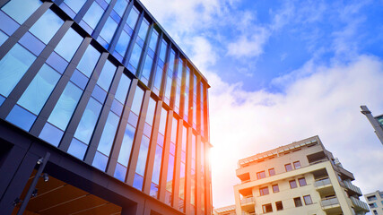 Glass buildings with cloudy blue sky background.  Perspective wide angle view to steel light blue background of glass.  Commercial modern city of future. Business concept of successful  architecture.