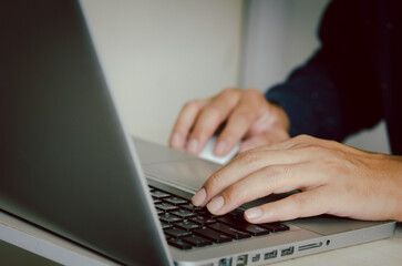 Man hand using a computer to type on a keyboard to find information on the Internet on social networks.