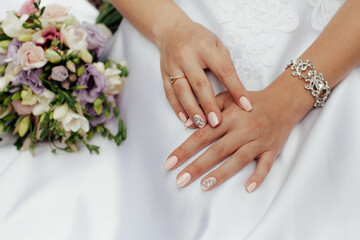 Obraz na płótnie Canvas Bride in a stylish white wedding dress. Nearby lies a stylish bouquet of colorful flowers.